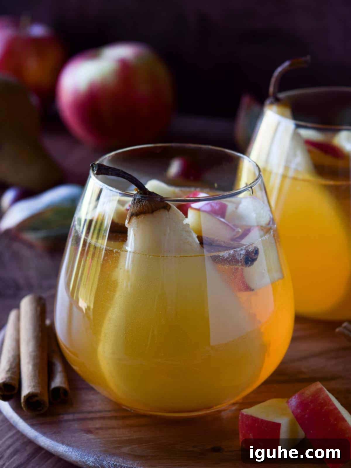 Close-up of apple and pear sangria in a glass, showcasing the vibrant fruit and inviting liquid.