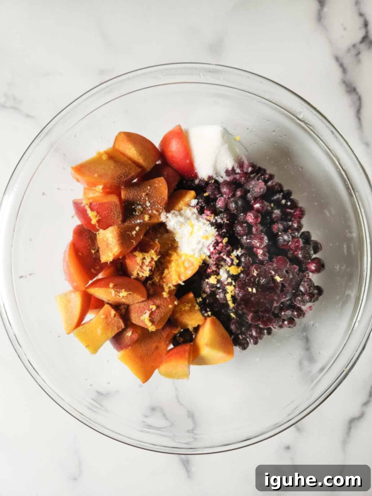 Summer Peach & Wild Blueberry Crumble 5 Peaches and blueberries prepared in a bowl for a crisp filling.