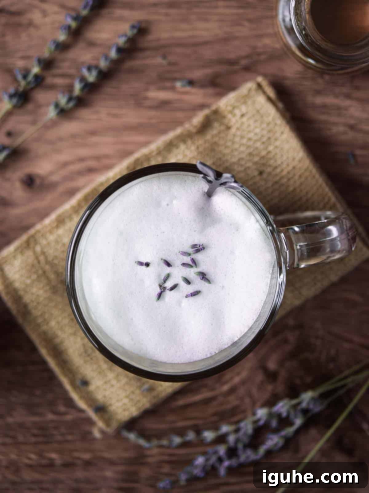 Lavender Bliss Latte 5 Overhead of a lavender tea latte on a wood background with lavender sprigs.