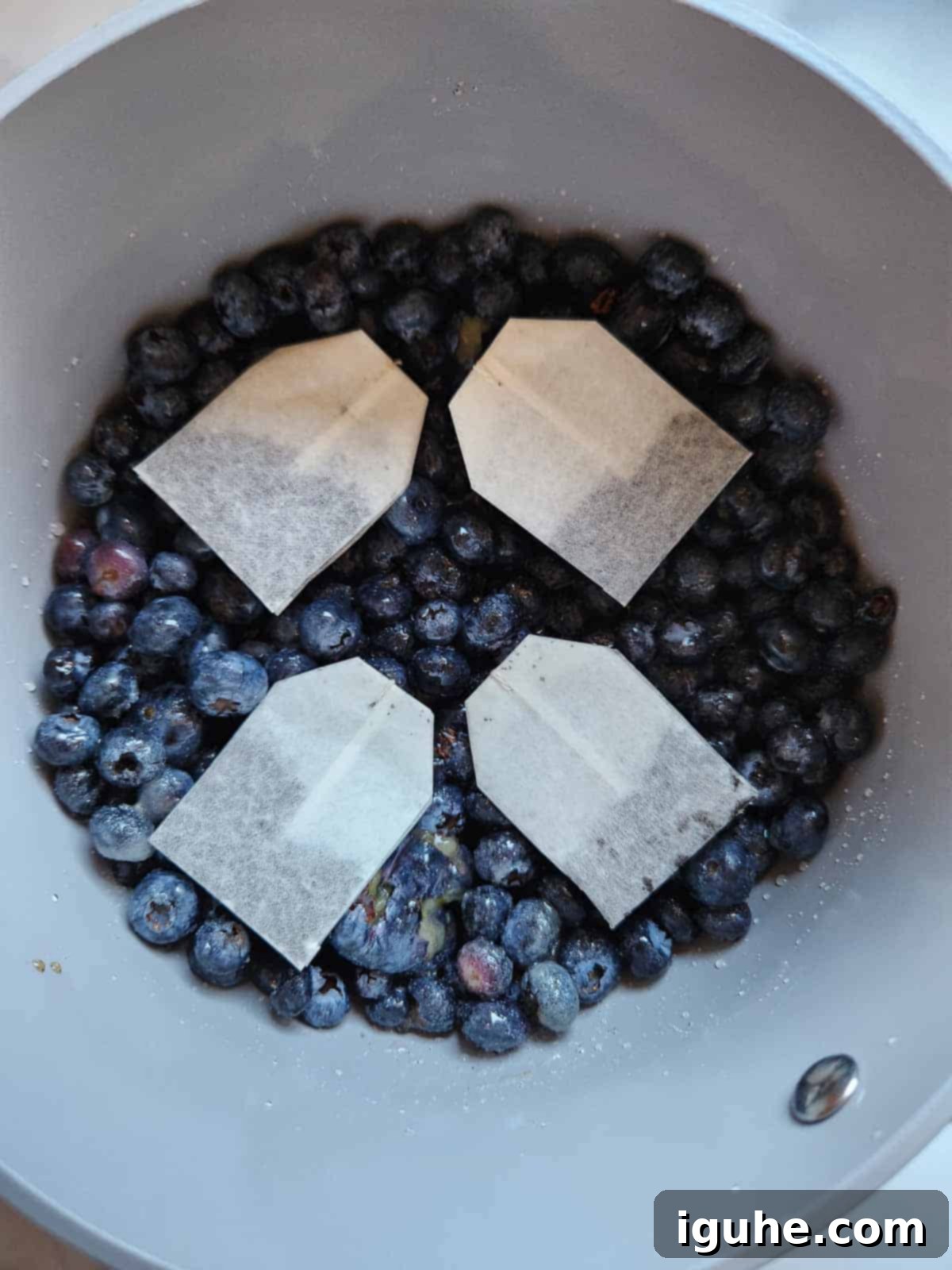 Blueberry Earl Grey Fridge Jam 5 Earl grey tea bags added to blueberry jam in a pot.