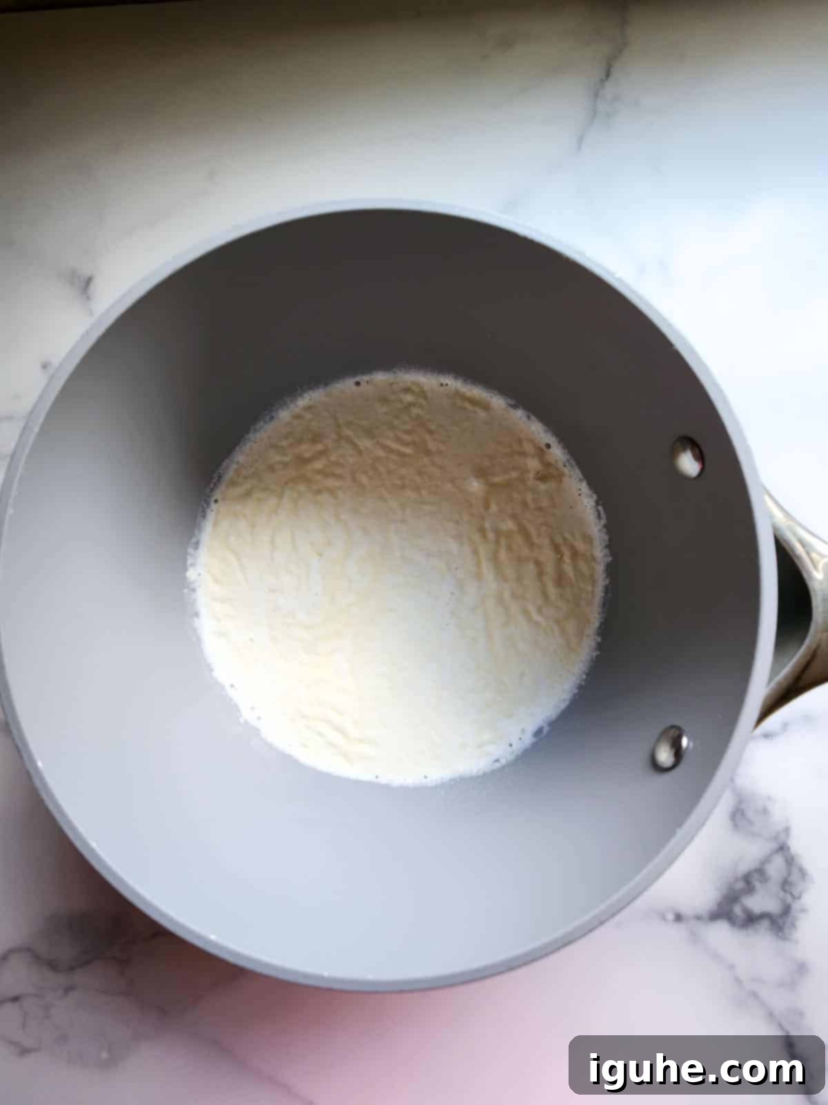 Velvet Espresso Panna Cotta 4 Gelatin powder sprinkled evenly over half and half in a medium saucepan, before heating, illustrating the 'blooming' process.