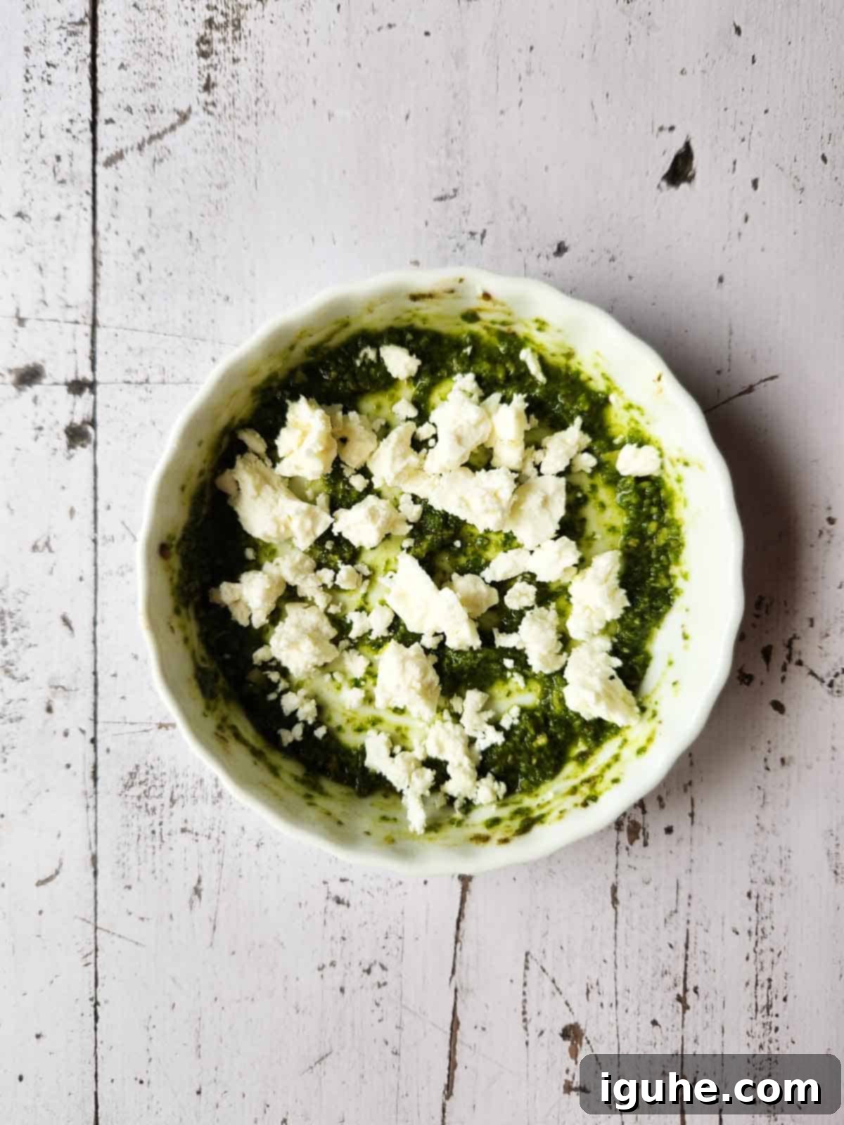 Pesto Egg Bake 5 Pesto sauce and feta in a white ramekin.