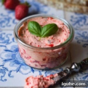 Strawberry Basil Cloud Butter 9 Close-up of creamy, light pink whipped strawberry basil butter in a clear glass jar, ready for serving.