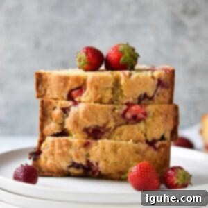 Buttermilk Kissed Strawberry Loaf 9 Strawberry buttermilk bread, sliced and stacked on a white plate.