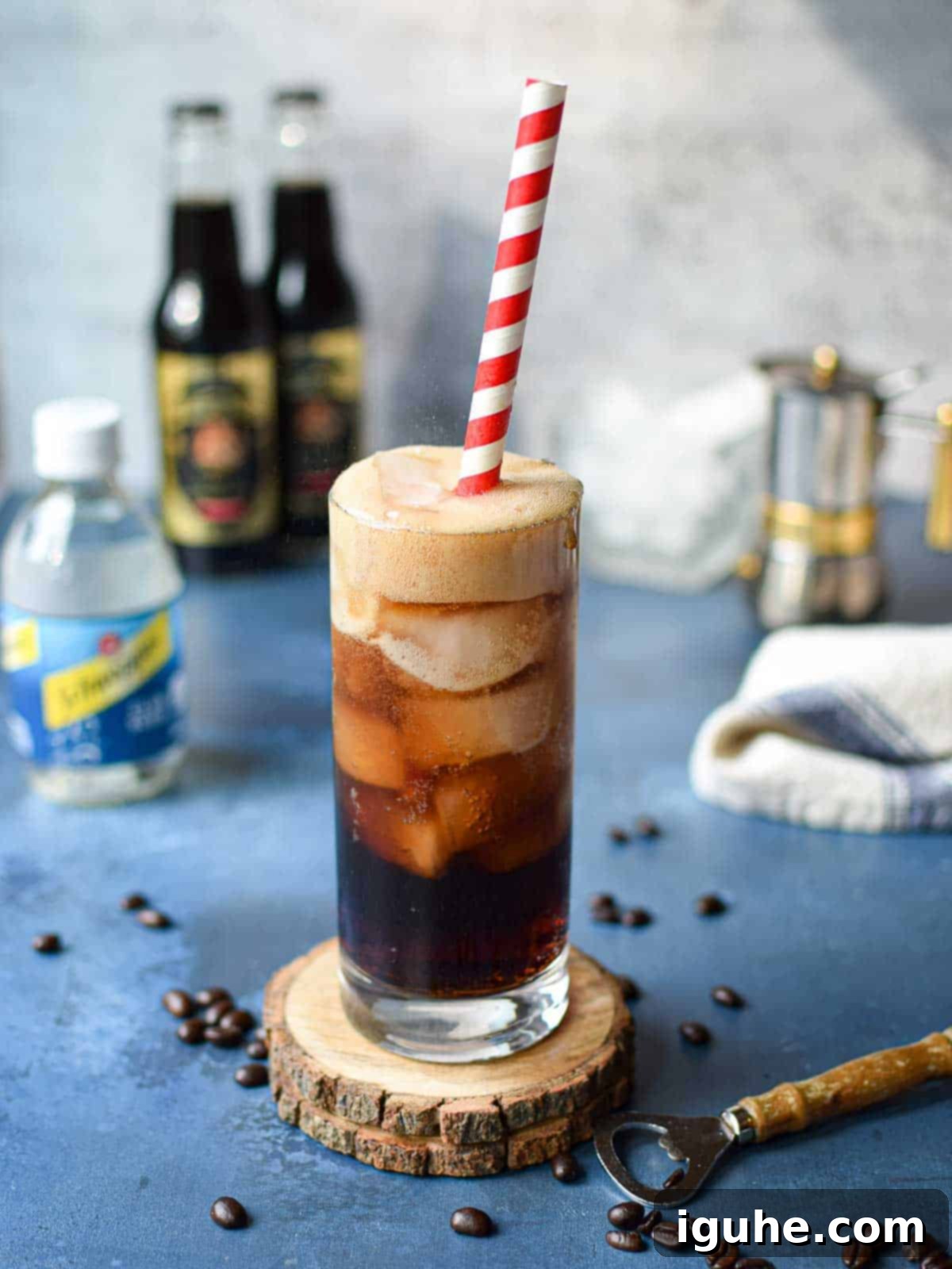 Espresso Sparkle 3 A glass of espresso soda with a red straw on a blue background, showcasing the vibrant drink.