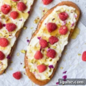 Bright Lemon Raspberry Ricotta Toast 10 Overhead and close-up view of gourmet lemon ricotta raspberry toast on white parchment paper, ready to be served for brunch.