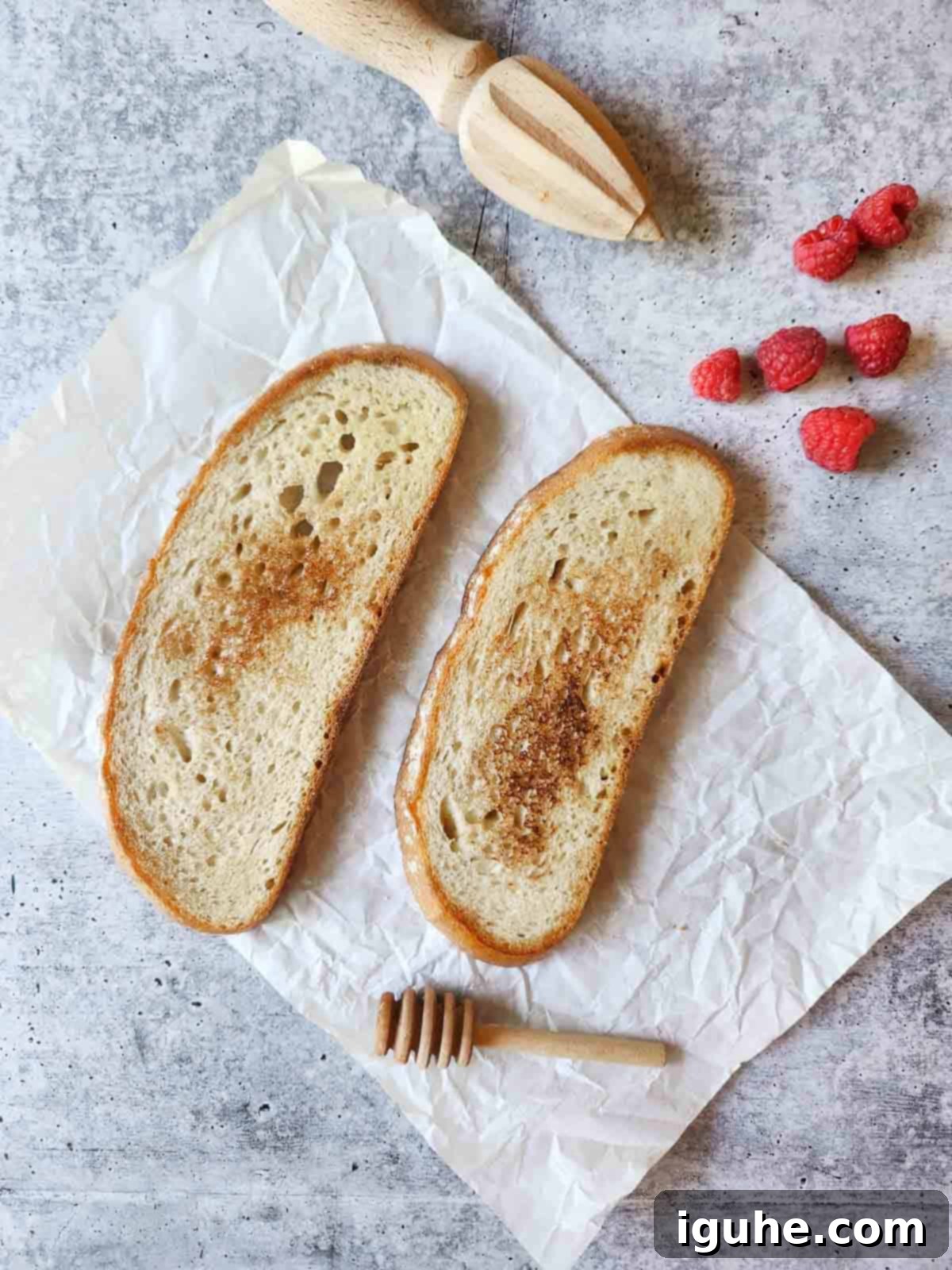 Bright Lemon Raspberry Ricotta Toast 4 Two slices of hearty toasted bread on parchment paper with fresh raspberries on the side, waiting for the creamy spread.