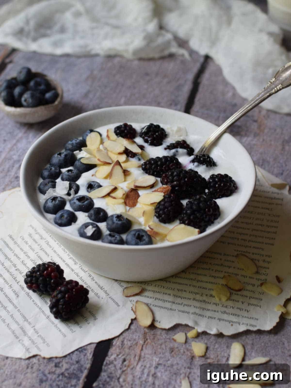 A vibrant bowl of fluffy, blended cottage cheese topped with fresh berries, sliced almonds, and a drizzle of honey, set against a bright, inviting background, ready for a delicious breakfast.