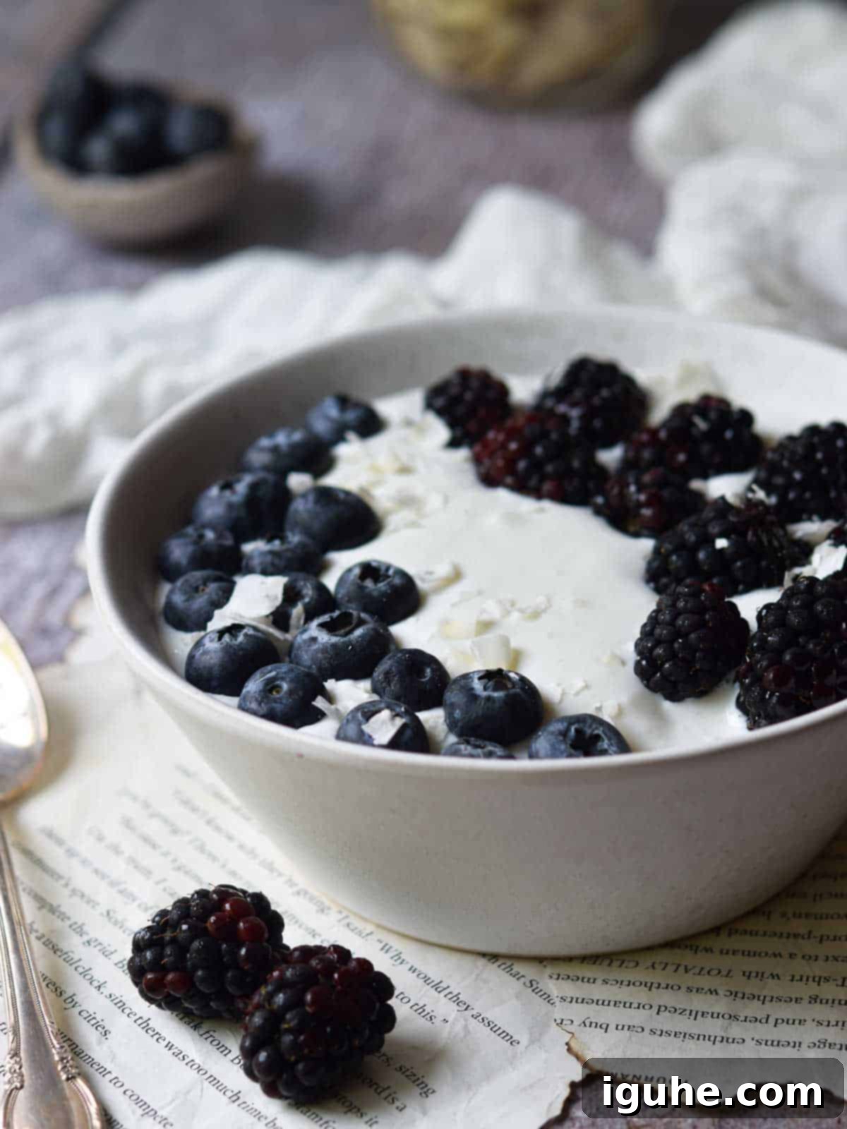 Creamy Cottage Cheese Breakfast Bowls 6 A beautifully arranged whipped cottage cheese bowl, garnished with fresh mixed berries and granola, resting on a rustic wooden surface, inviting you to dig in.