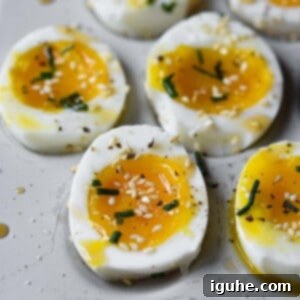 Sesame Kissed Jammy Eggs 9 Soft-boiled eggs with sesame oil and toasted sesame seeds cut open.