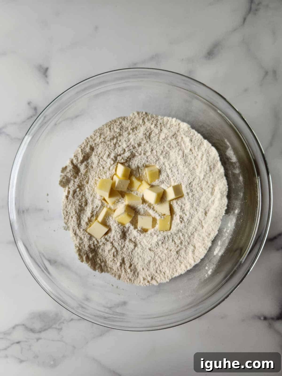 Buttery Raspberry Almond Scones 5 Cold cubed butter being cut into flour mixture using a pastry blender.
