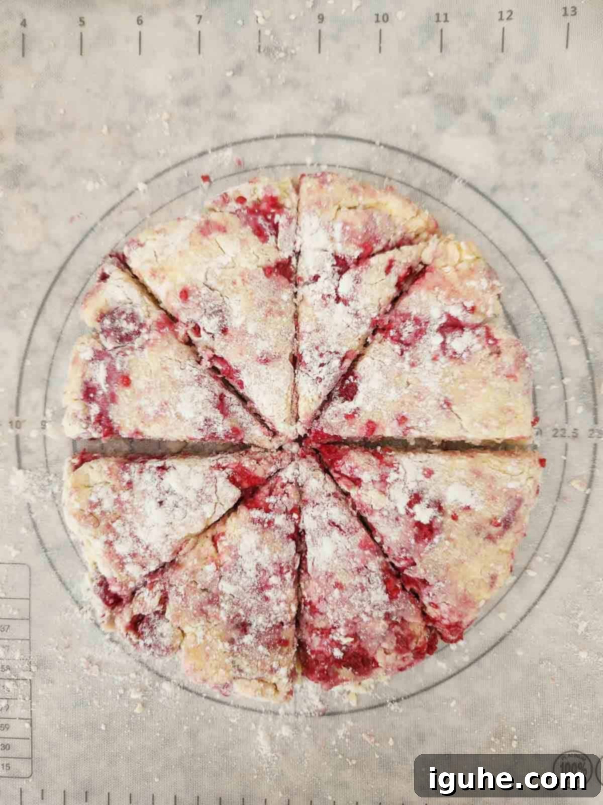 Buttery Raspberry Almond Scones 7 Raspberry scone dough shaped into a circle and cut into 8 even triangles.
