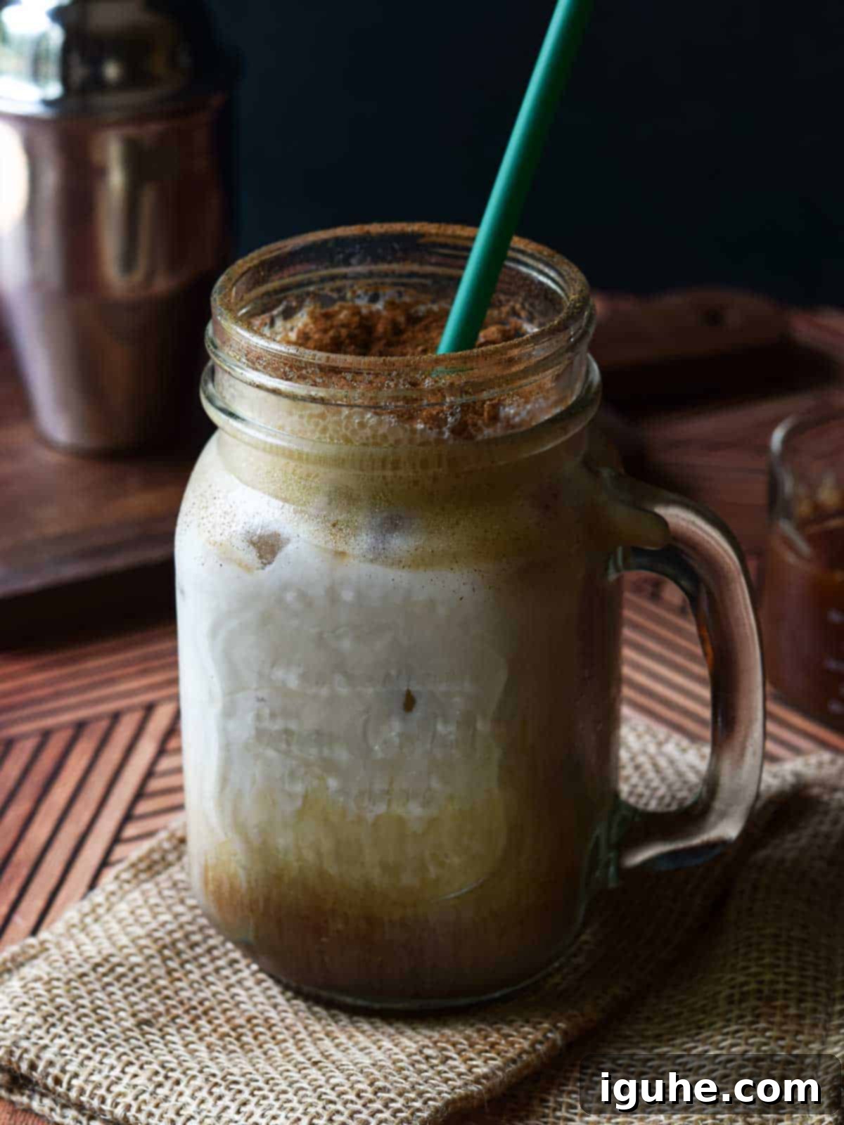 Caramel-Kissed Shaken Chai 8 Close-up of a perfectly crafted brown sugar shaken chai drink in a handled glass mug, showing layers of tea, ice, and foam.