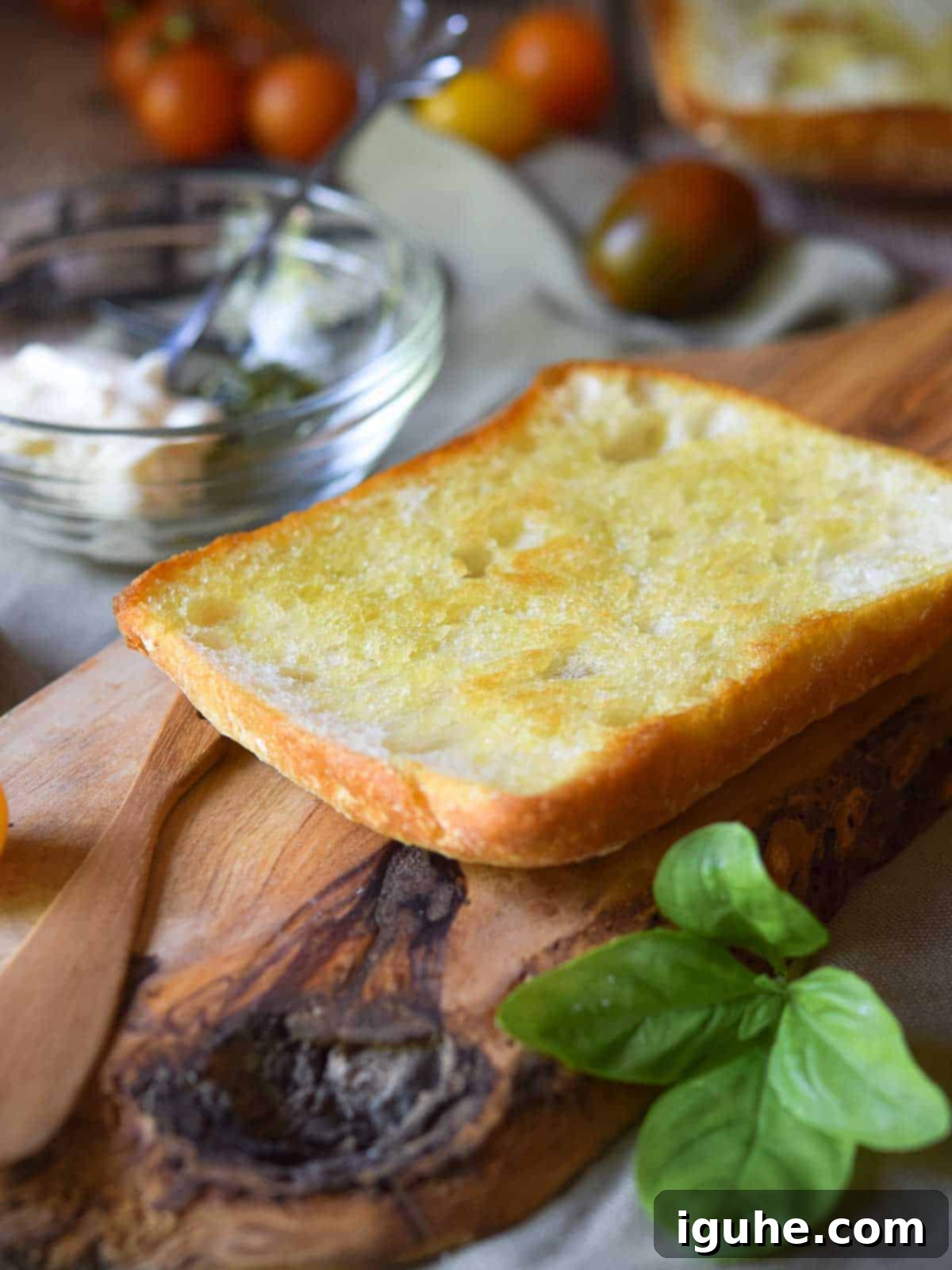 Sun-Kissed Heirloom Tomato & Pesto Aioli Sandwich 5 Toasted ciabatta on a wood board.