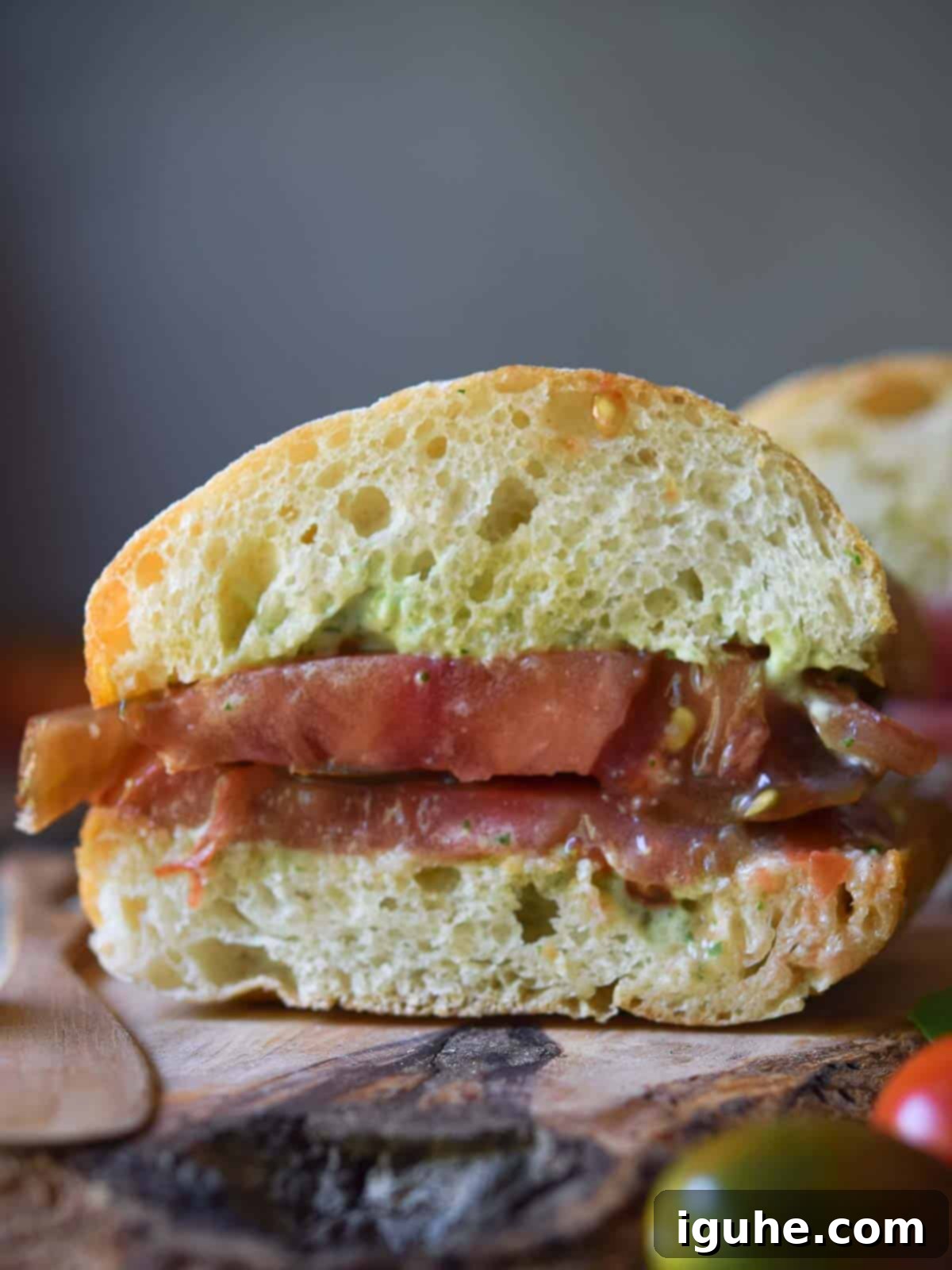 Sun-Kissed Heirloom Tomato & Pesto Aioli Sandwich 9 Close-up of a tomato ciabatta sandwich cut open.