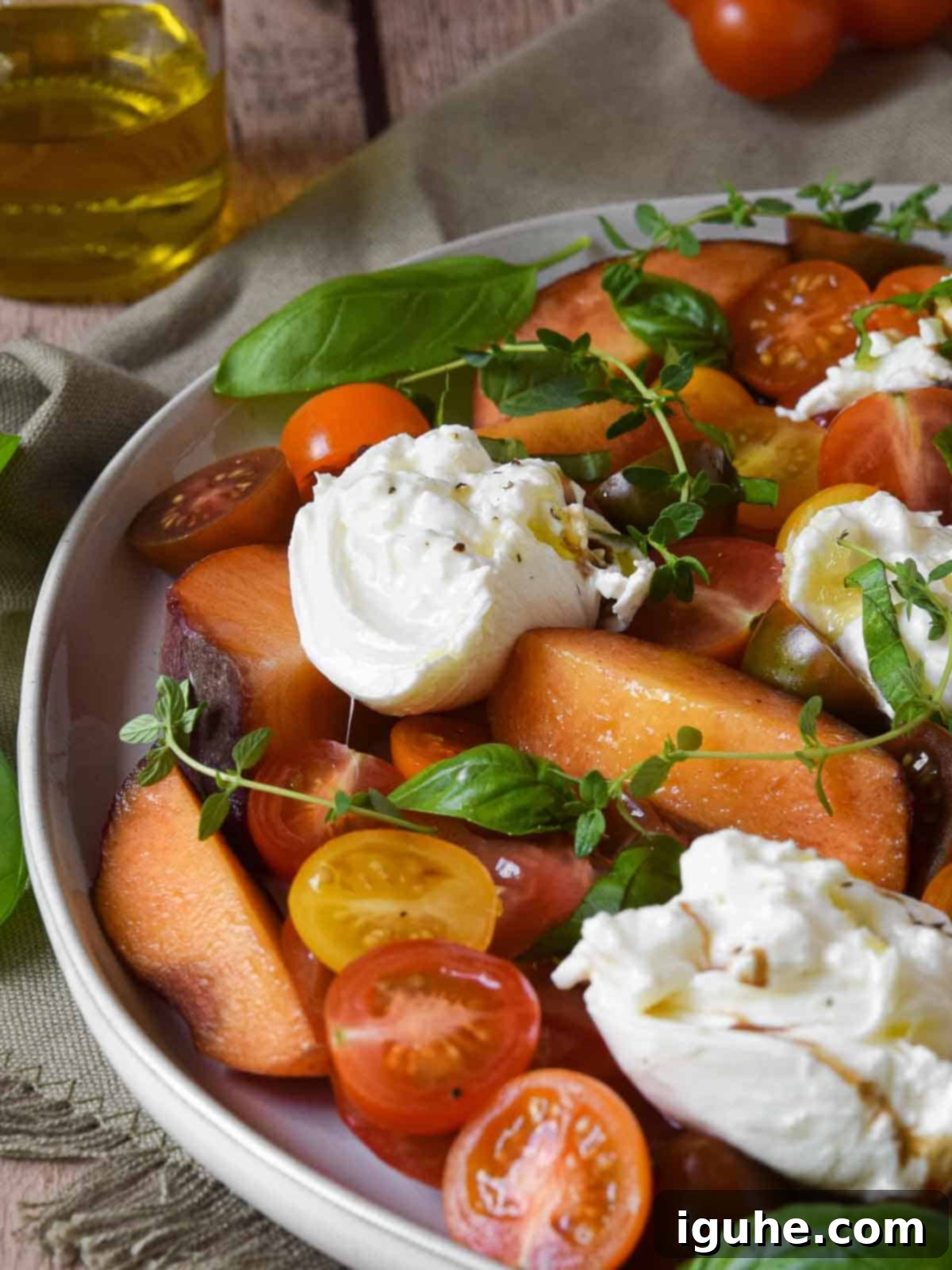 Peaches and Cream Burrata Caprese 8 Close-up view of the creamy burrata, sweet peaches, and colorful tomatoes in the Burrata Caprese Salad, showcasing its inviting texture.