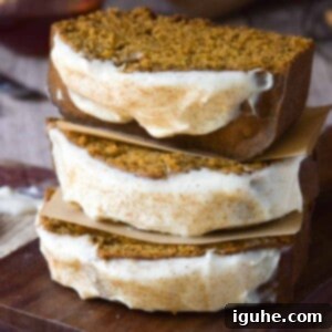 Warm Spiced Pumpkin Bread with Maple Cream Cheese Frosting 10 Three slices of pumpkin bread with maple cream cheese frosting stacked on top of each other.