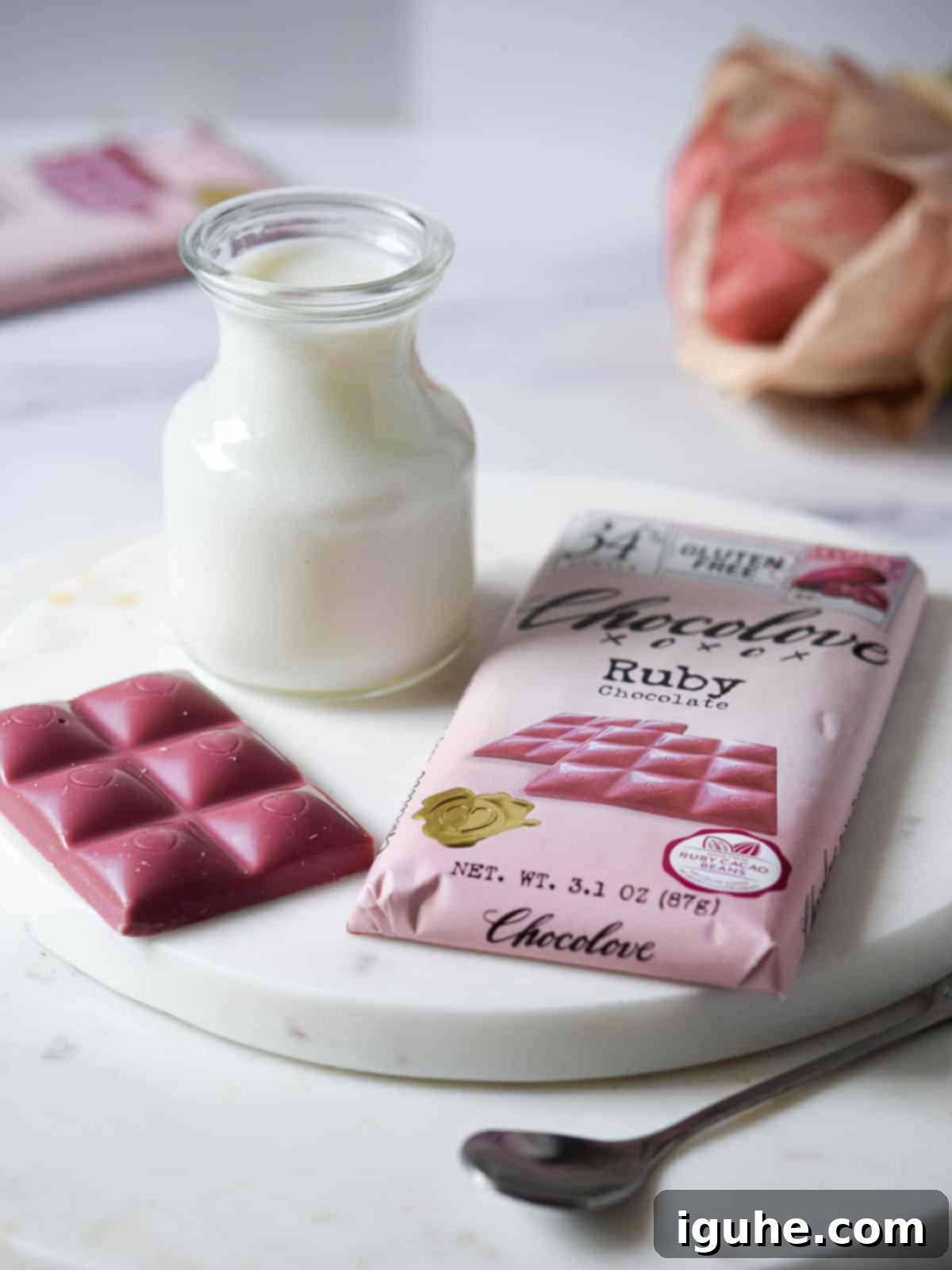 Velvet Ruby Hot Cocoa 3 Ingredients for ruby hot chocolate laid out on a white marble board, showcasing the ruby chocolate bar and milk.