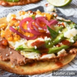 Quick and Delicious Huevos Rancheros Tostadas 10 Huevos rancheros tostadas on newspaper with a lime in the background.