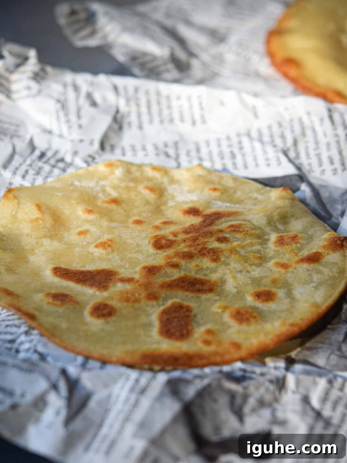 Quick and Delicious Huevos Rancheros Tostadas 5 Fried tostada on a newspaper.