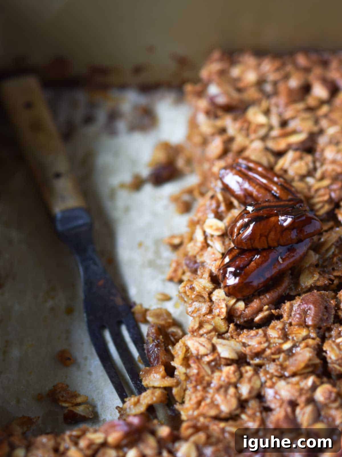 Decadent Pecan Pie Baked Oatmeal 3 Pecan pie oatmeal in a baking pan, with a large slice removed, showing its soft and chewy texture.