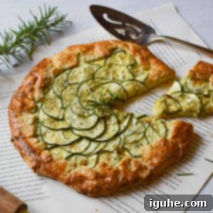 Rustic Zucchini Ricotta Tart 8 Angled view of zucchini ricotta galette with a slice cut out on a white background