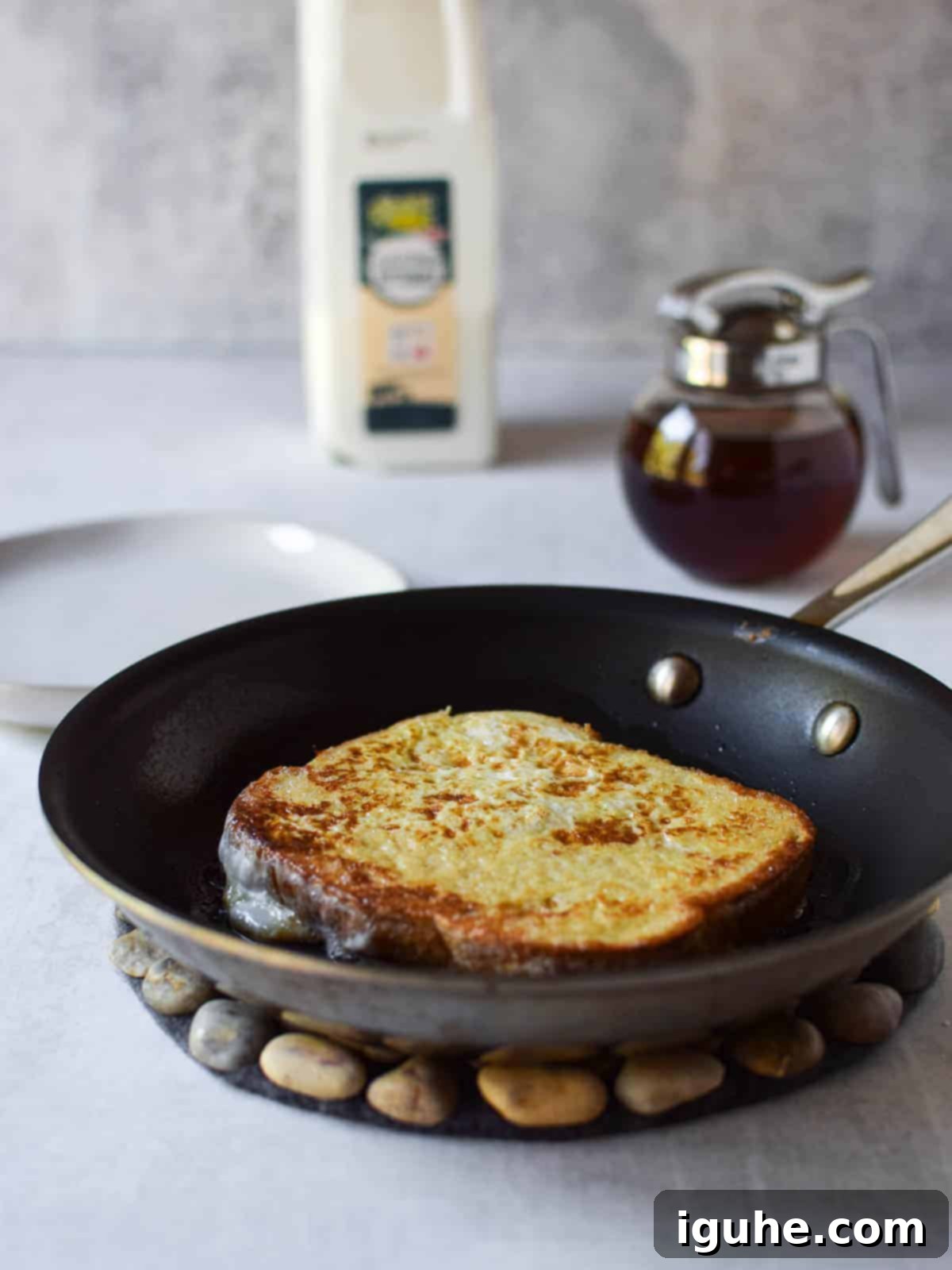 Repurposed Buttermilk French Toast 10 A perfectly golden-brown cooked French toast slice in a frying pan, ready to be served.