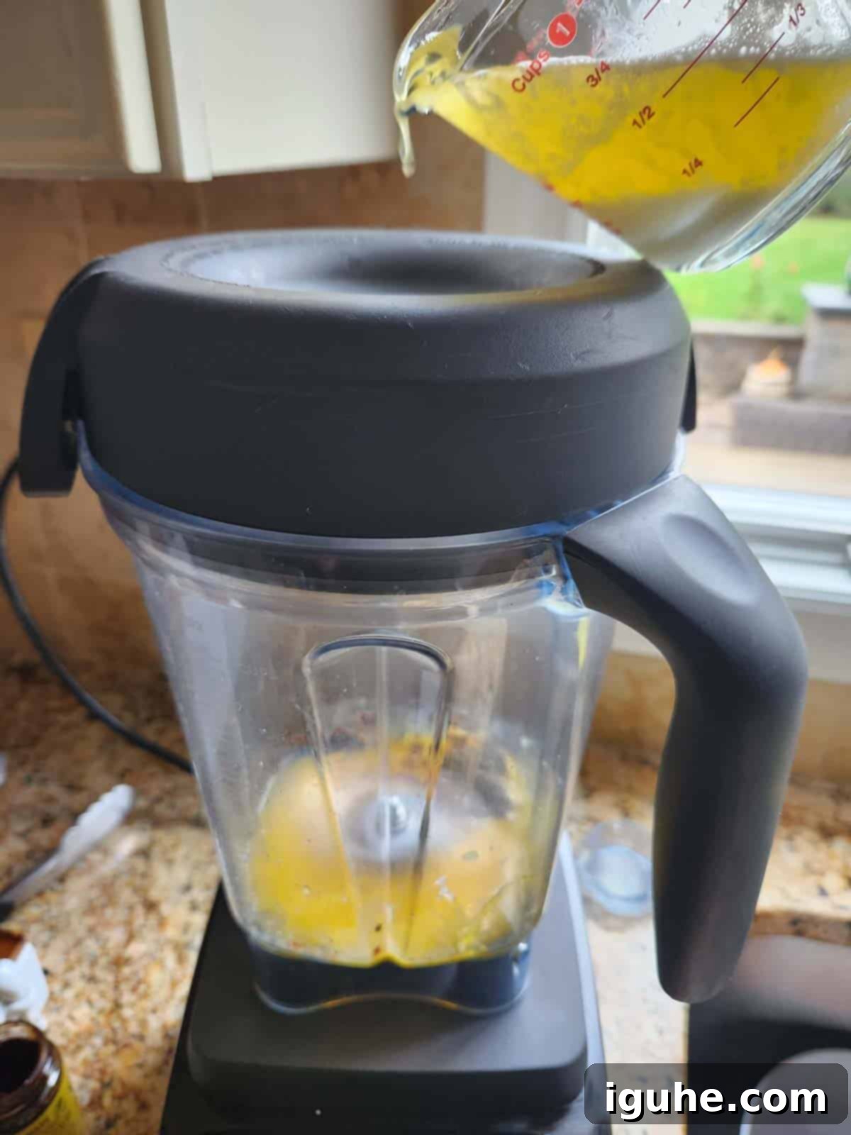 Fiesta Benedict with Chipotle Kick 10 Hot melted butter being poured into a blender with egg yolks for making hollandaise sauce.