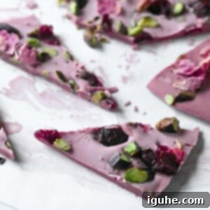 Blush Ruby Chocolate Bark 10 Cut up pieces of ruby chocolate bark on parchment paper.
