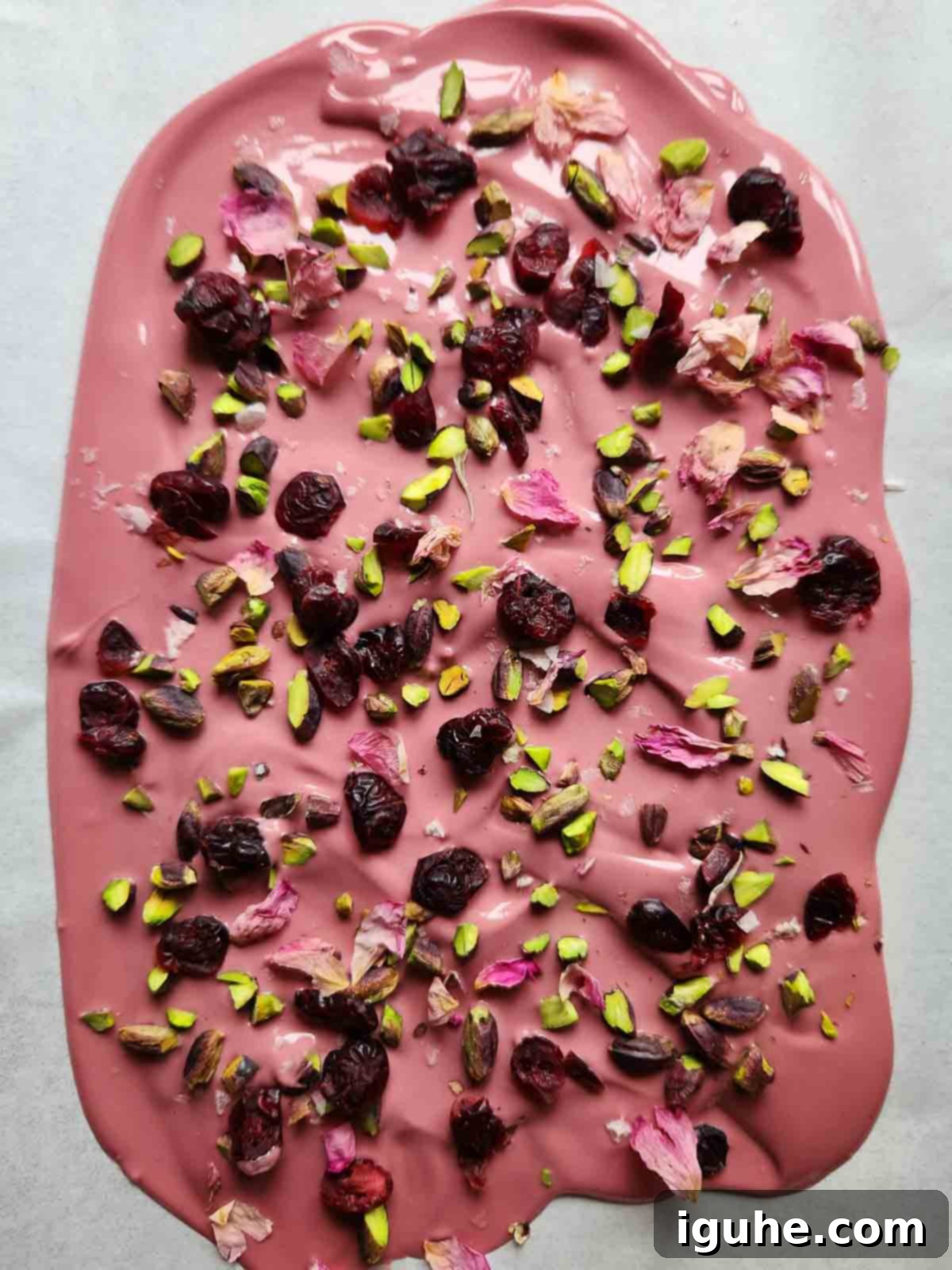 Blush Ruby Chocolate Bark 7 Melted ruby chocolate with toppings on parchment paper.