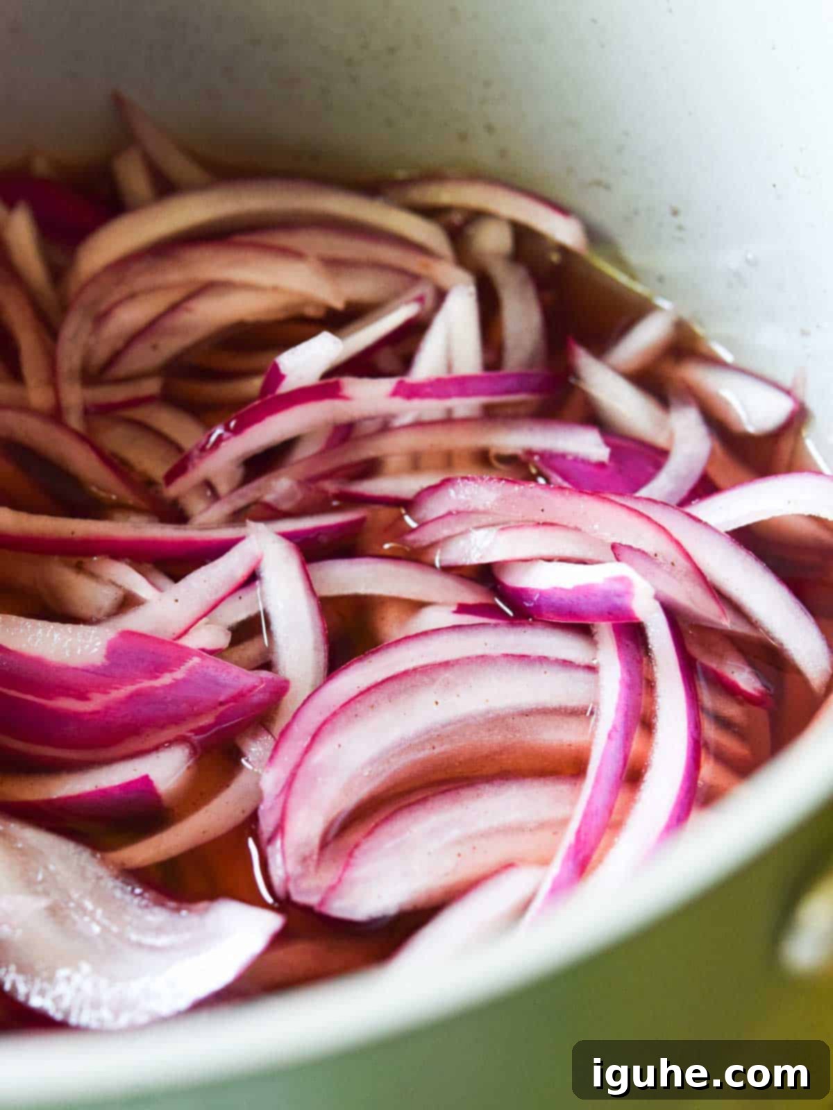 Sweet Heat Pickled Onions 6 Sliced red onions added to the hot pickling liquid in a pot.
