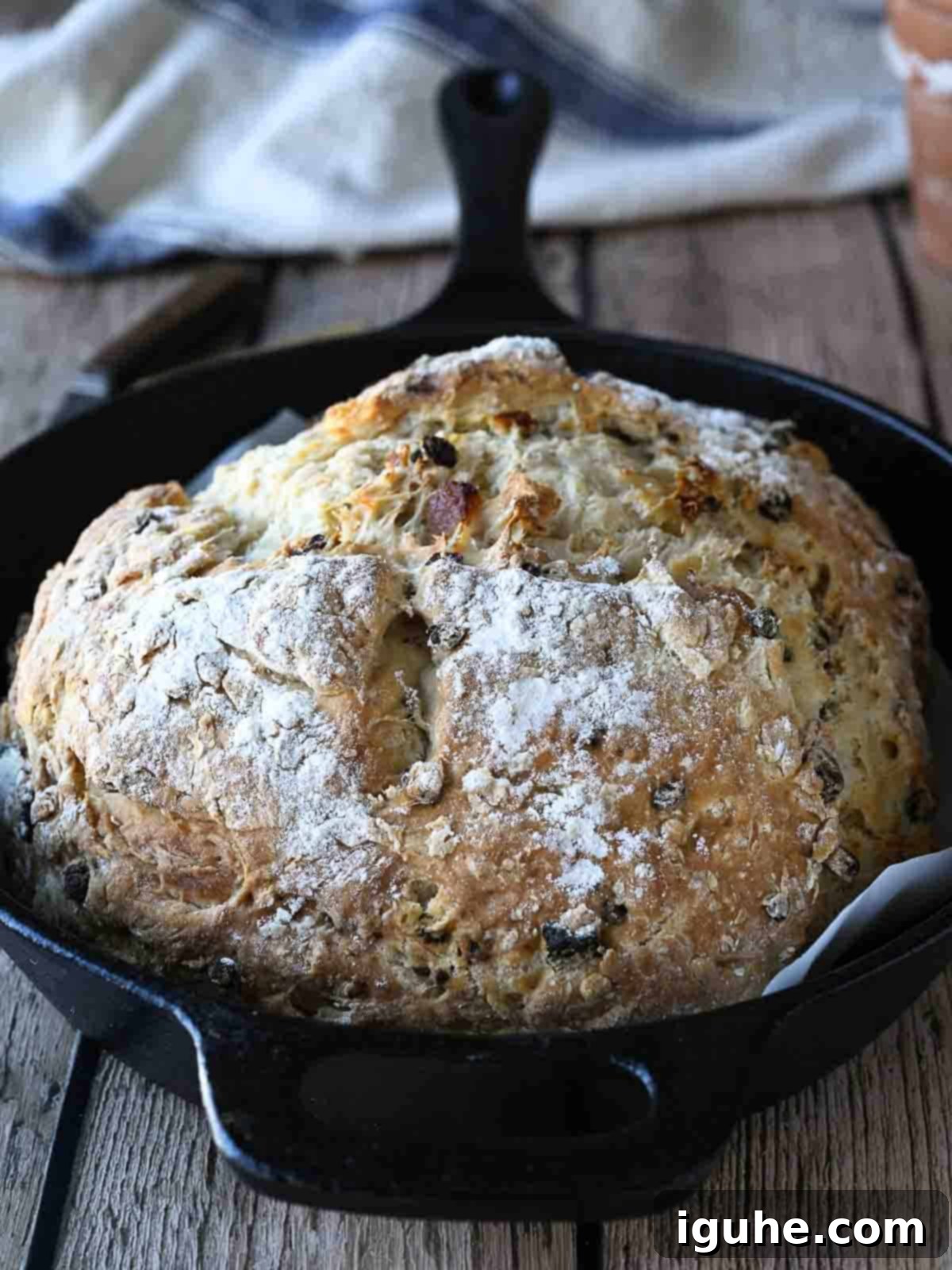 Sun-Kissed Apricot and Currant Irish Soda Bread 8 Irish soda bread in a cast iron skillet on a wood surface.