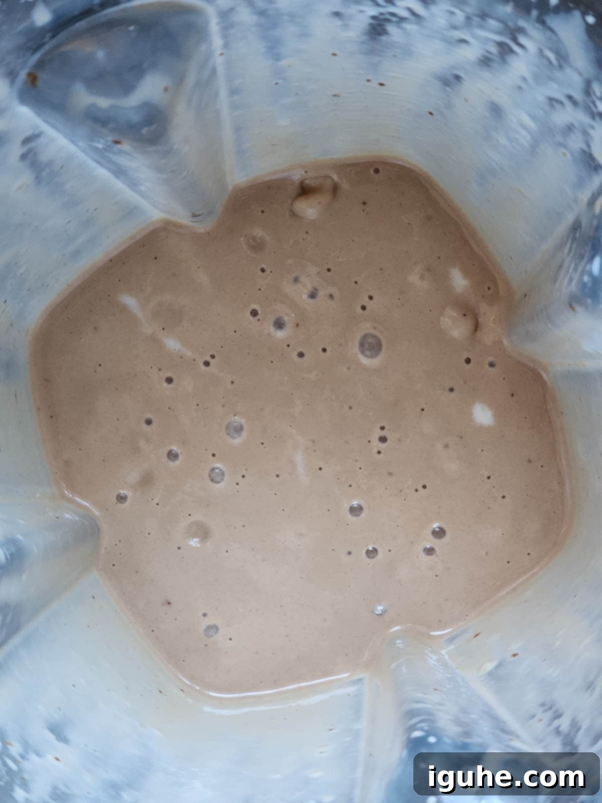 Decadent Chocolate Tahini Oat Milk Smoothie 5 Chocolate tahini oat milk smoothie blending to a smooth consistency in a blender.