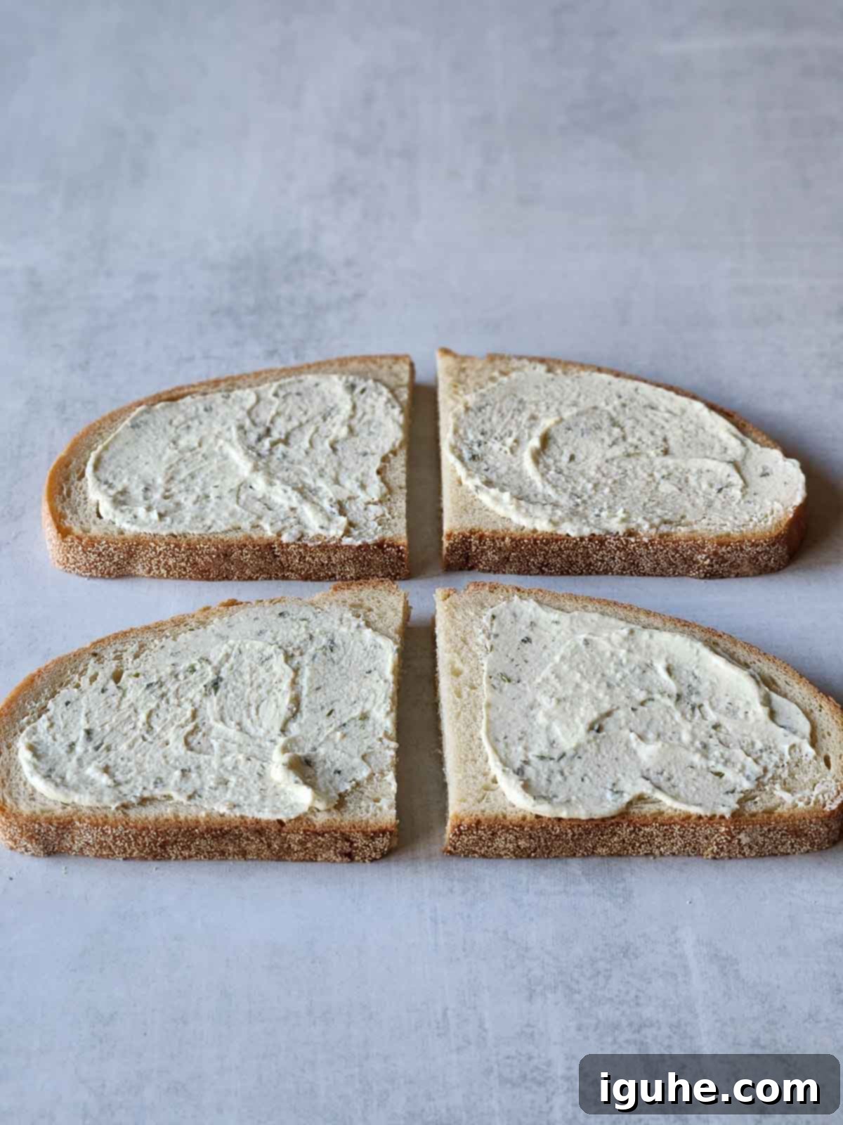 Blackberry Boursin Grilled Delight 4 Four slices of bread with Boursin cheese evenly spread on one side of each slice.