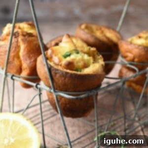 Fluffy Lemon Thyme Delights 10 Lemon popovers are suspended in a wire rack with thyme and lemons in the forefront.