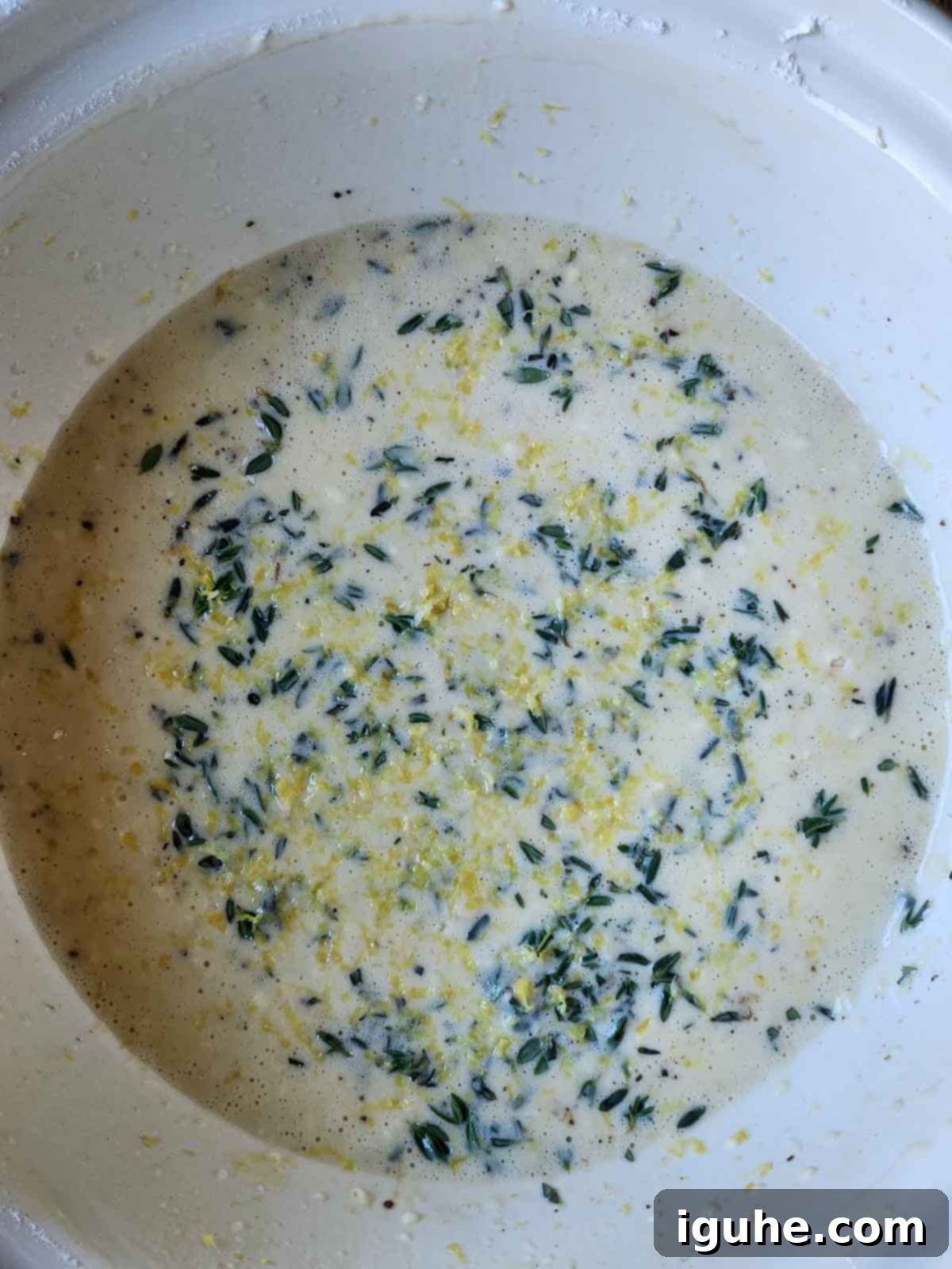 Fluffy Lemon Thyme Delights 6 Overhead shot of the finished lemon thyme popover batter, perfectly smooth with visible flecks of green thyme and yellow lemon zest.