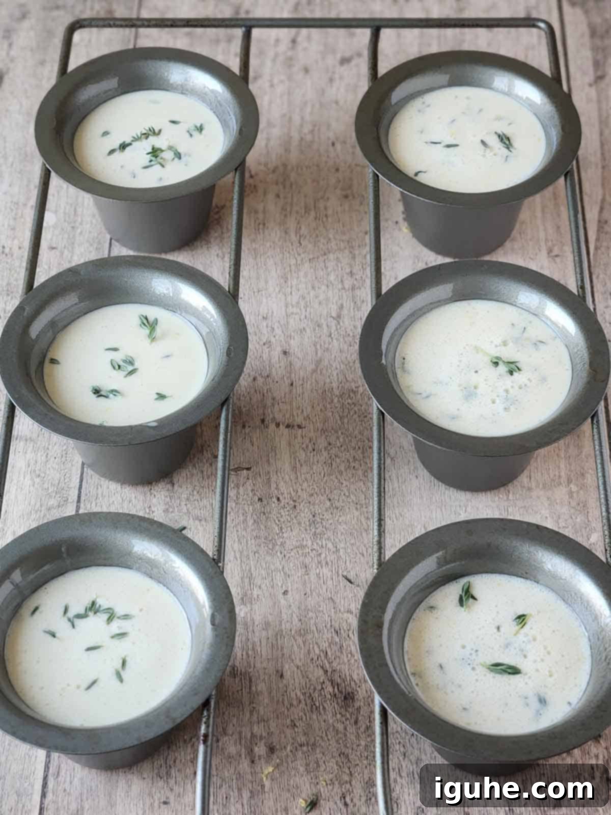 Fluffy Lemon Thyme Delights 7 Popover batter poured into the wells of a 6-well popover pan, ready for the oven.