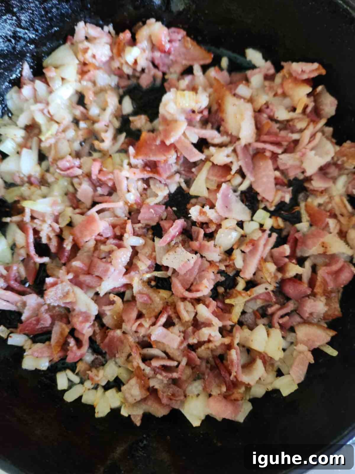 Bourbon-Kissed Bacon Bliss 5 Sautéed onions and bacon in a cast iron skillet.