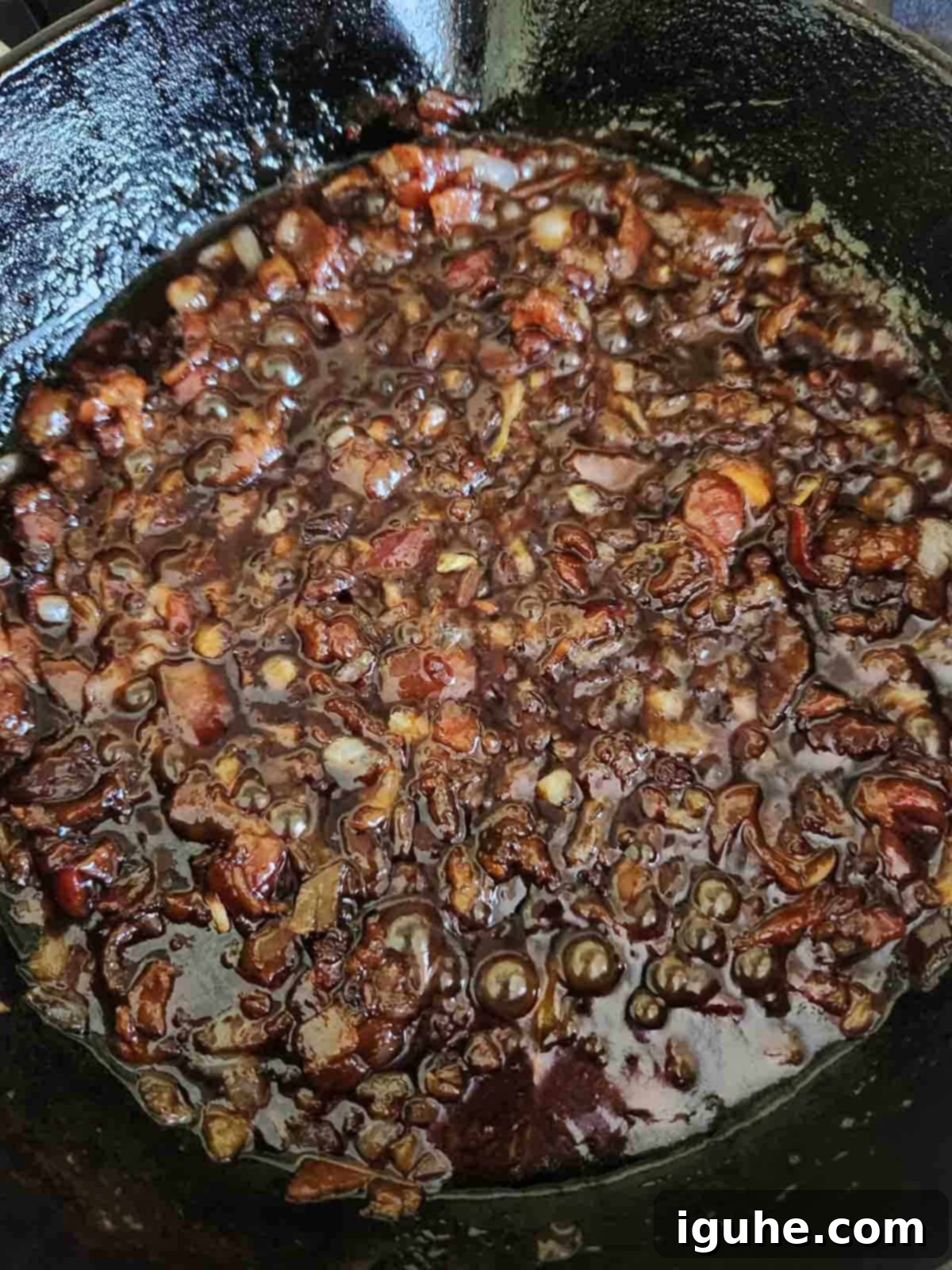 Bourbon-Kissed Bacon Bliss 7 Caramelized bacon chutney cooking in a cast iron skillet.