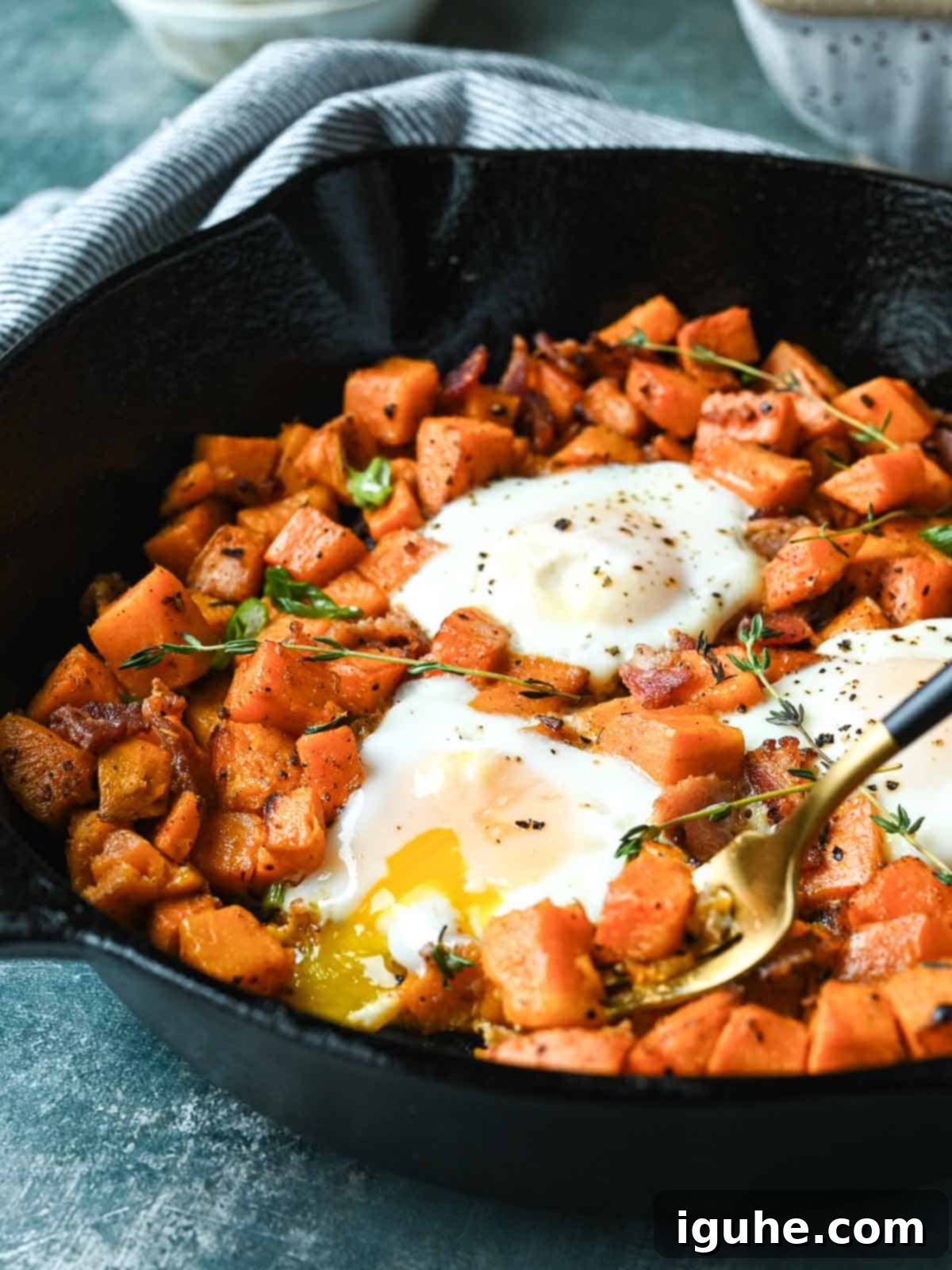 Sunrise Sweet Potato Bacon Medley 11 Sweet potato and bacon hash in a skillet with thyme sprigs on top.