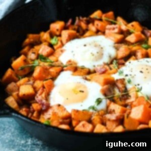 Sunrise Sweet Potato Bacon Medley 12 Close-up of sweet potatoes and bacon hash in a skillet with thyme sprigs on top.