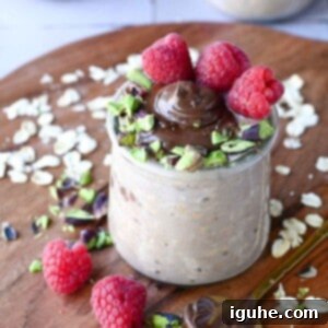 Decadent Nutella Overnight Oats 7 Close-up of Nutella overnight oats with raspberries and pistachios.