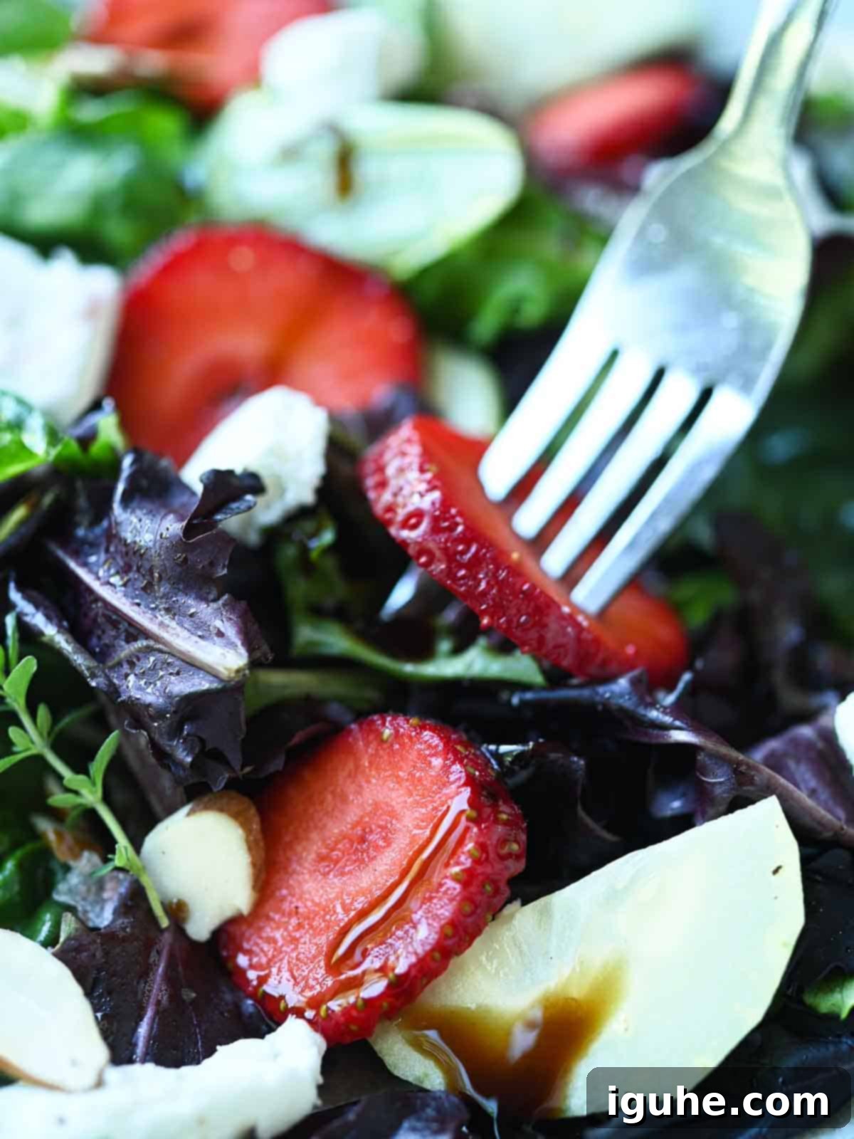 Strawberry Goat Cheese Salad 5 Close-up of a fork in a salad of strawberries and goat cheese.