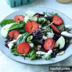 Strawberry Goat Cheese Salad 6 Strawberry salad with goat cheese and lettuce on a white plate.
