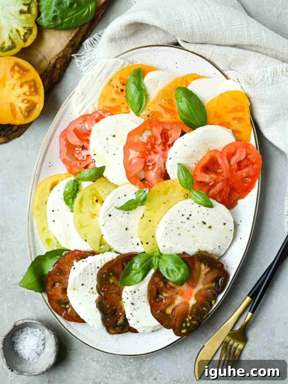 Overhead of Italian Caprese salad on a white platter.
