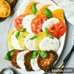 Vibrant Heirloom Caprese Salad 10 Overhead of Caprese salad on a white platter.