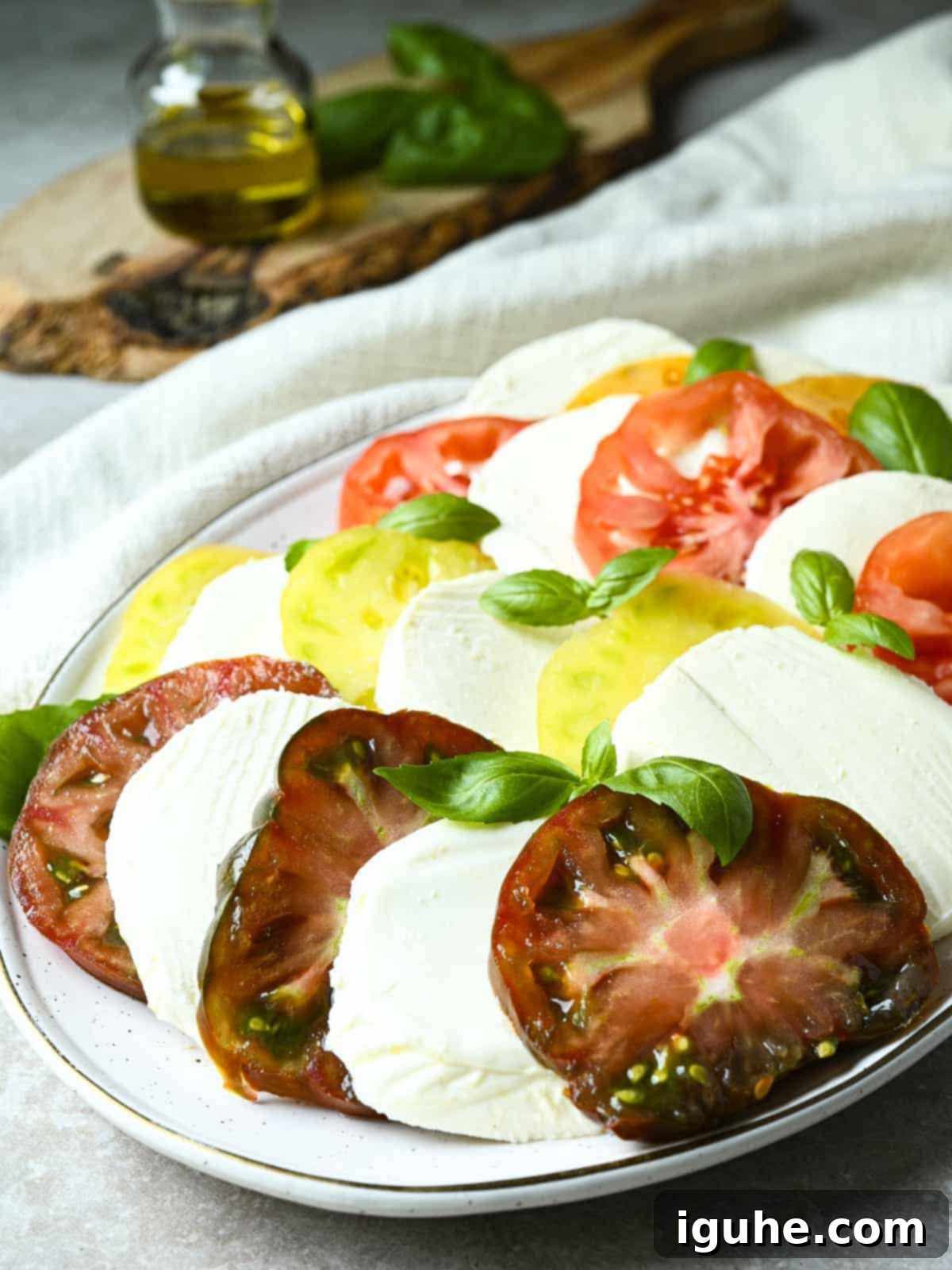 Vibrant Heirloom Caprese Salad 6 Sliced tomatoes in different colors layered with mozzarella slices.