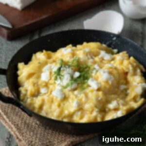 Mediterranean Feta Dill Scramble 10 Scrambled eggs in a black skillet with feta and dill on top.