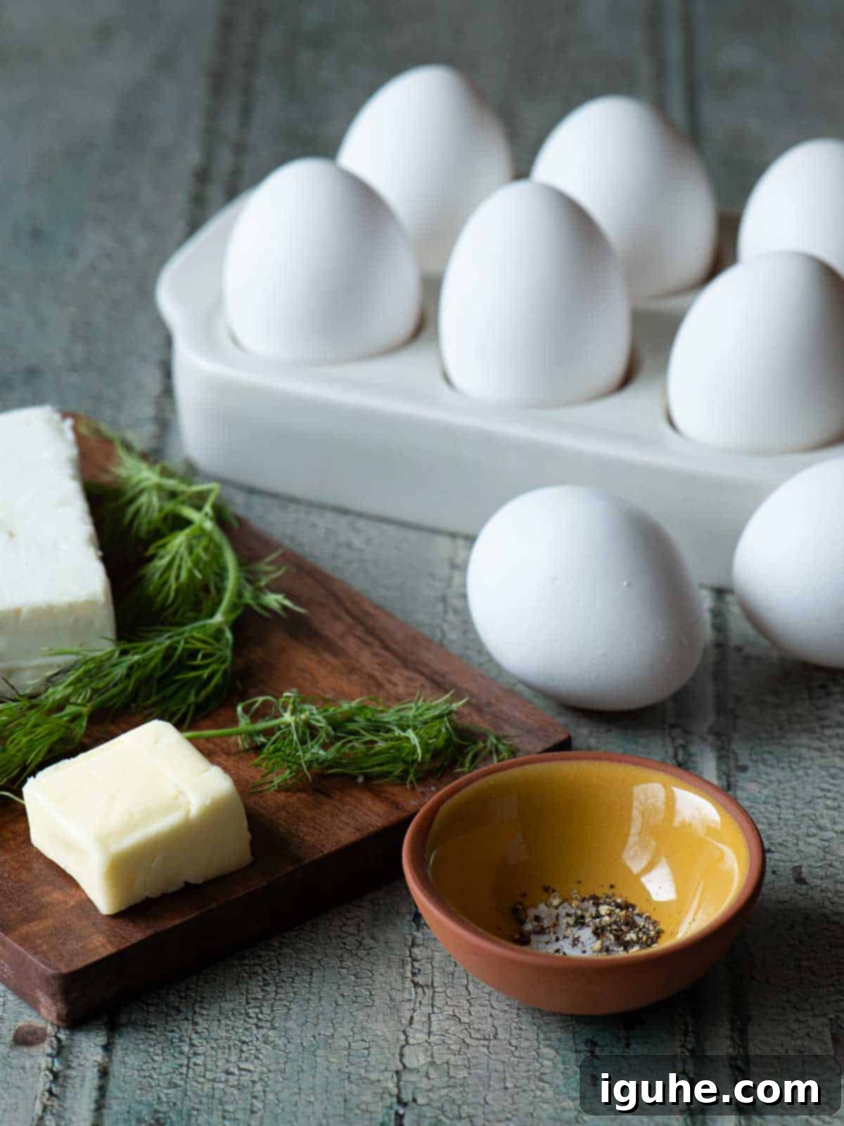 Mediterranean Feta Dill Scramble 3 Ingredients for scrambled eggs on a wood board.