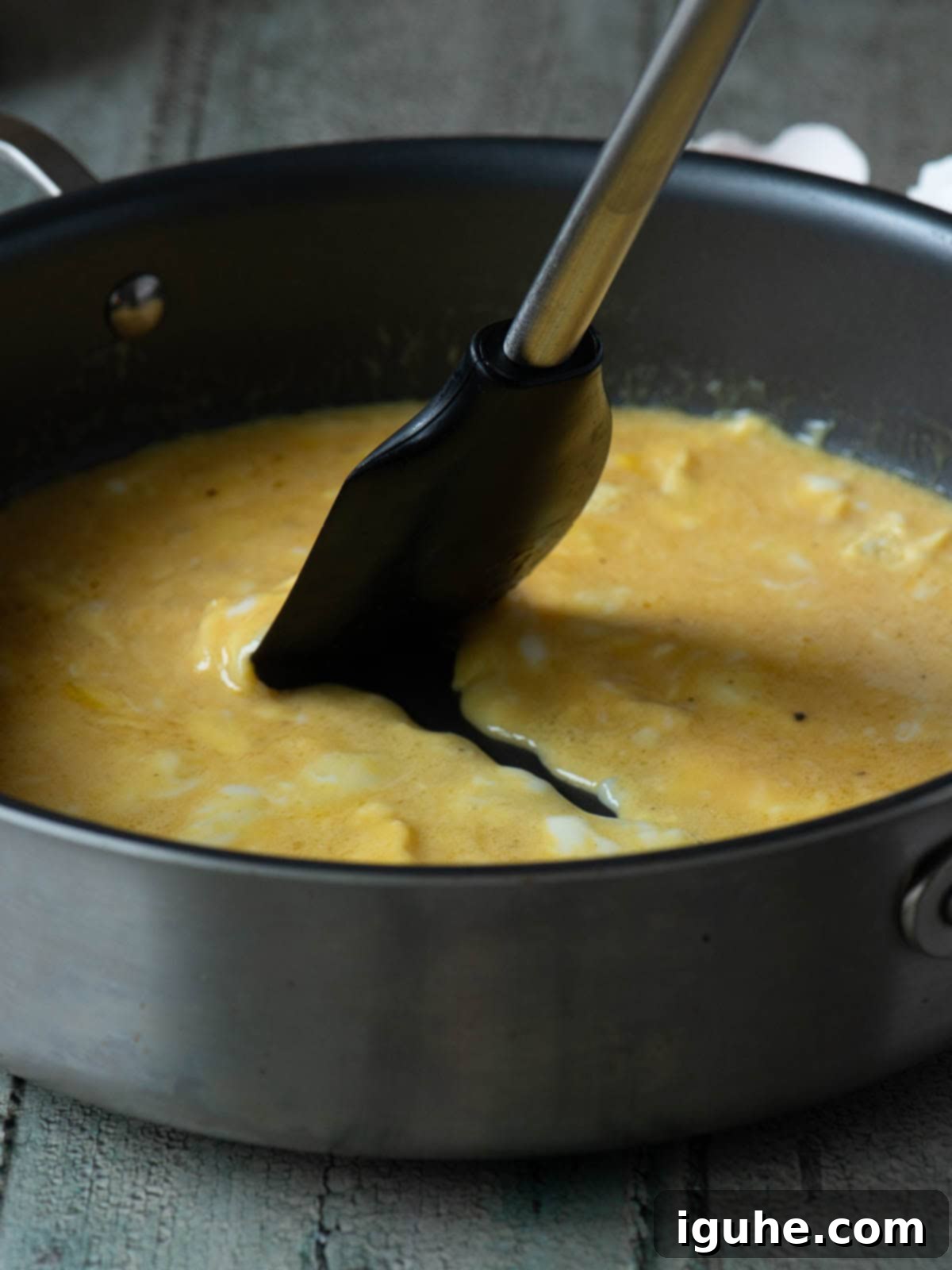 Mediterranean Feta Dill Scramble 5 Scrambled eggs being mixed with a spatula in a skillet.